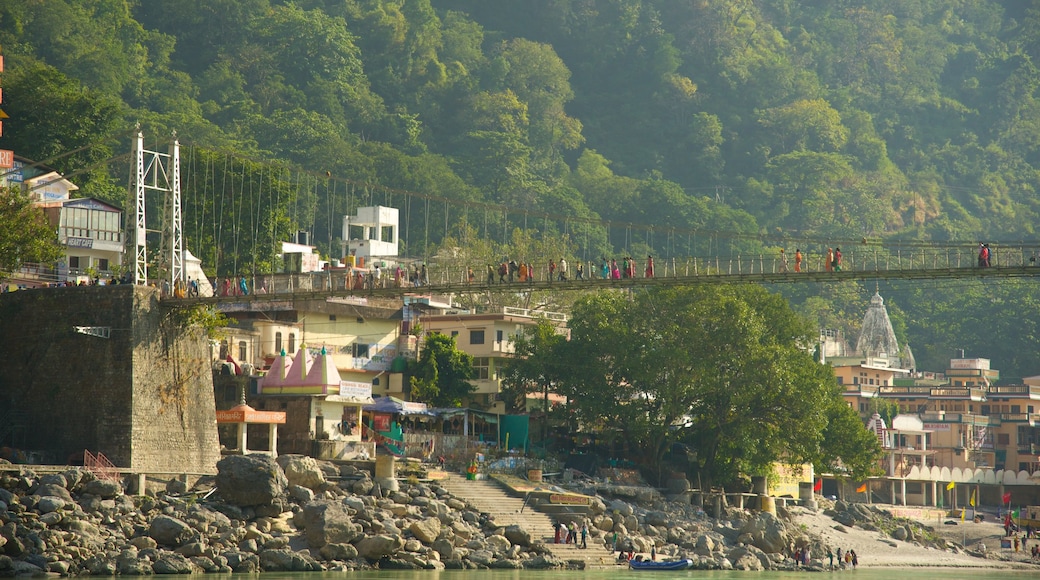 Lakshman Jhula che include piccola città o villaggio, fiume o ruscello e ponte