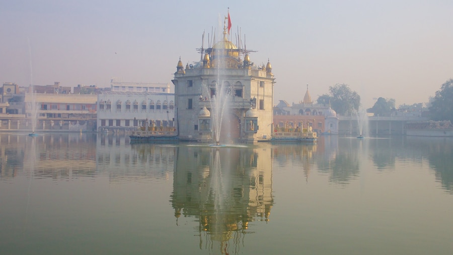 Durgiana Temple featuring a temple or place of worship, a lake or waterhole and heritage elements