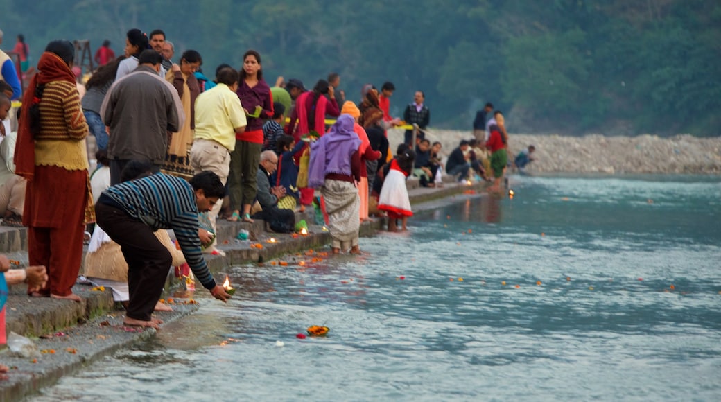 Triveni Ghat mostrando aspectos religiosos y un río o arroyo y también un gran grupo de personas