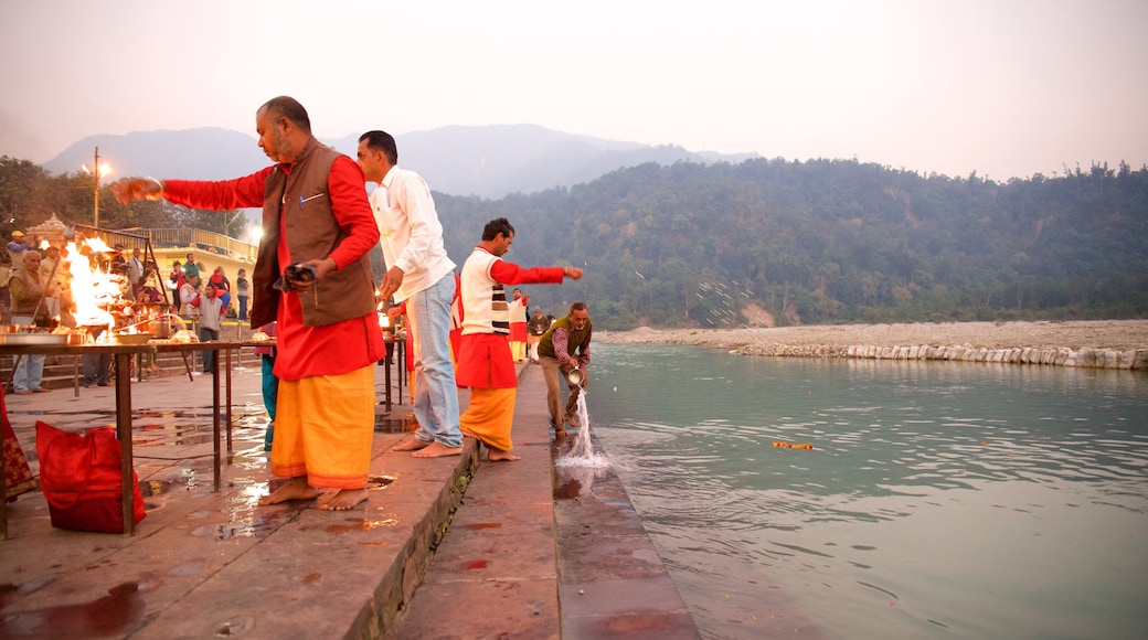 Triveni Ghat ofreciendo un río o arroyo y aspectos religiosos y también un pequeño grupo de personas