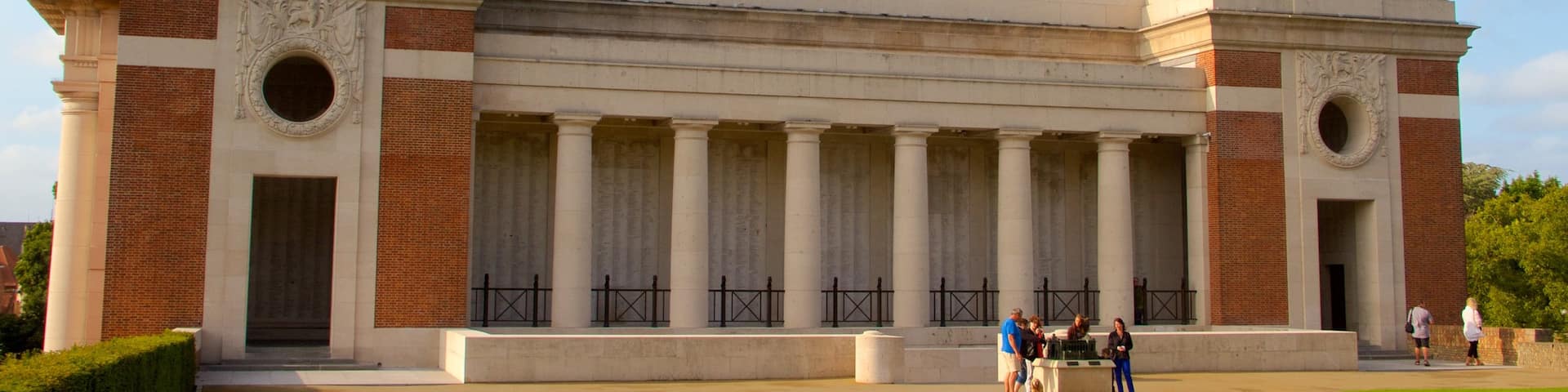 Menin Gate Memorial featuring heritage elements and a park as well as a small group of people