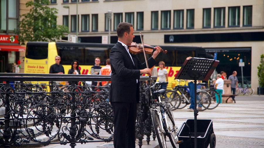 Gendarmenmarkt montrant musique et art de rue aussi bien que homme