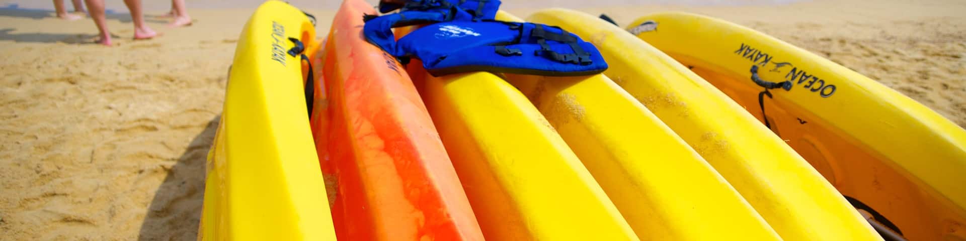 Las Caletas Beach featuring a sandy beach and kayaking or canoeing as well as a small group of people