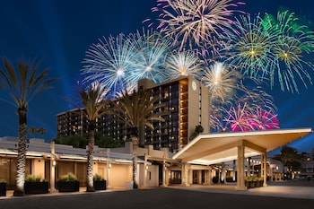 A hotel with a modern design, featuring a large building with multiple floors and a prominent entrance area.