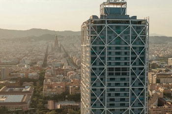 Ein moderner Poolbereich mit einer einzigartigen Architektur, Palmen und freiem Blick auf den Ozean.