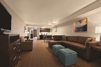 A spacious lobby with a central seating area, stone walls, and large televisions on either side.