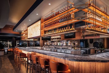 A Starbucks with a large logo, a bar area, and seating with tables and chairs.