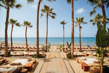 På stranden, liggestole, parasoller, badehåndklæder