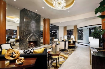 Un hall d’hôtel moderne doté d’une cheminée, d’un espace salon et d’un coin repas.