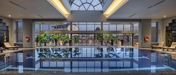 Una piscina cubierta, sombrillas, tumbonas