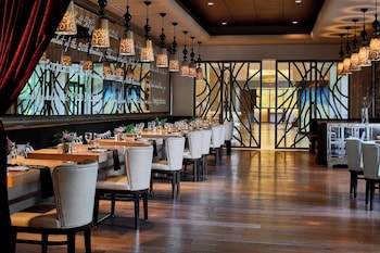 Enjoy a meal with a breathtaking view of the mountains from this dining area, featuring a unique light fixture and elegant table settings.