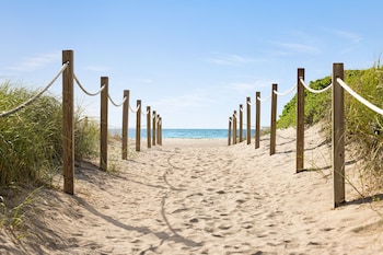 Nær stranden, hvit sand og strandhåndklær