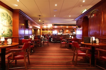 A grand lobby with a chandelier, plush seating, and a patterned carpet.