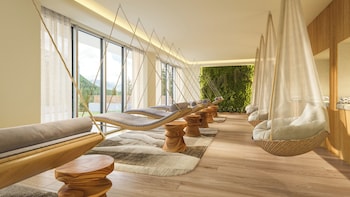 An outdoor seating area with fire pits, umbrellas, and a view of trees and mountains.