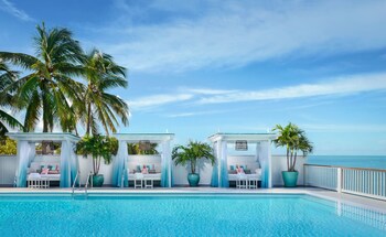 A pool area with lounge chairs and a cabana.