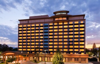A modern hotel with a large entrance, multiple floors, and a covered parking area.
