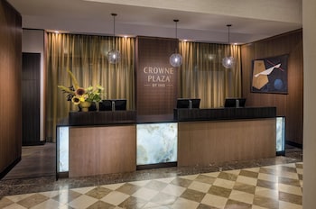 A modern hotel lobby with a bar area, seating arrangements, and large windows.