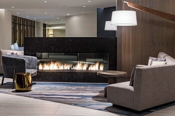 A Marriott hotel with a fountain, outdoor seating, and a Starbucks sign.