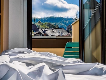Un hôtel à plusieurs étages dont l’image se reflète dans l’eau, caractérisé par un style architectural homogène, avec des fenêtres en arc et des balcons.