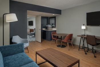 A hotel atrium with multiple floors, a central courtyard with palm trees, and a sign reading "Welcome to the Four Points by Sheraton Tampa Airport Westshore."