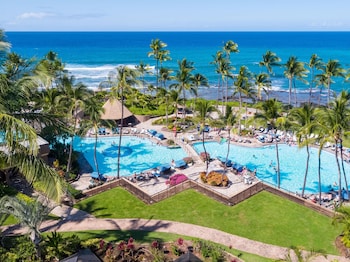 Un resort con piscina, playa y vista al océano.