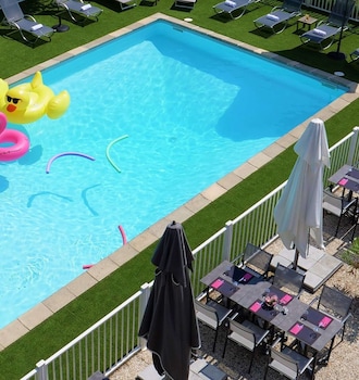 Un intérieur moderne agrémenté d’un foyer central, de poutres en bois et d’un coin salon confortable.