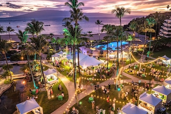 A resort with multiple swimming pools, a beach, and a mountain in the background.
