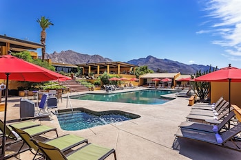 Un resort con piscina, zona de estar exterior y vistas a la montaña.
