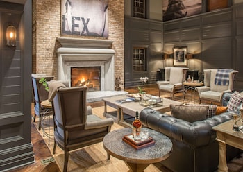 A spacious indoor area with high ceilings, exposed beams, and a mix of seating arrangements including tables and chairs.