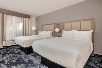Un hotel de varios pisos con un llamativo letrero azul que dice 'CITY EXPRESS BY MARRIOTT'.