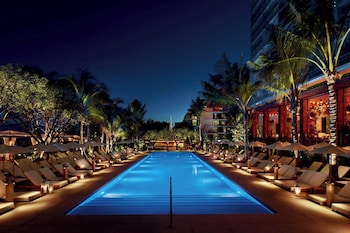 Relax by the pool surrounded by comfortable lounge chairs and umbrellas.