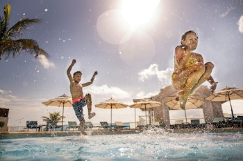 Relax by the ocean with a clear view of the sandy shoreline from this pool area.