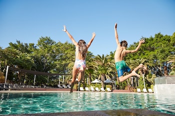 Een buitenzwembad, parasols bij het zwembad en ligstoelen