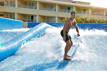 A resort with a large swimming pool, beach access, and multiple buildings.