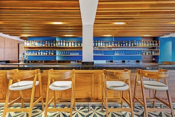 A spacious indoor venue with multiple round tables and chairs, a tiled floor, and a high ceiling with star-shaped decorations.