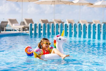 Alberca al aire libre, sombrillas en la alberca y camastros