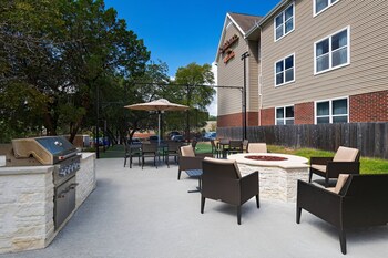 A spacious conference room with a large table, multiple chairs, a fireplace, and large windows.