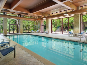 A multi-story hotel with a covered entrance, stone pillars, and a landscaped garden.