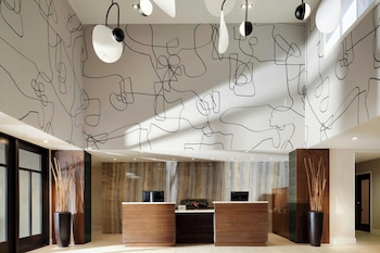 A modern lounge area with leather seating, a fireplace, and large windows offering views of the outdoors.