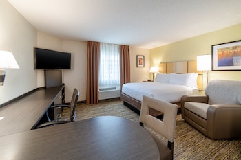 Une chambre d’hôtel équipée d’une kitchenette, d’un lit, d’un bureau et d’une chaise.
