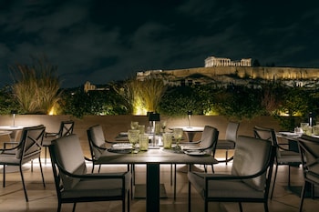 An outdoor dining area with tables and chairs, overlooking a historic building.