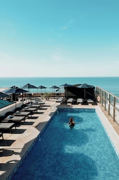 Una piscina al aire libre, camas de piscina gratis, sombrillas