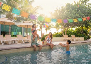 A resort with multiple buildings, a swimming pool, and a beach.