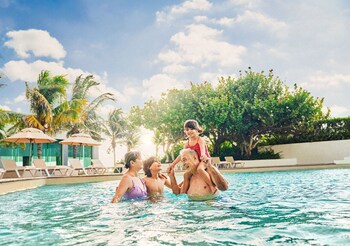 Un complexe hôtelier comprenant plusieurs bâtiments, une piscine et une plage.