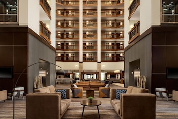 A spacious lobby with a central seating area, multiple floors of balconies, and a modern design.