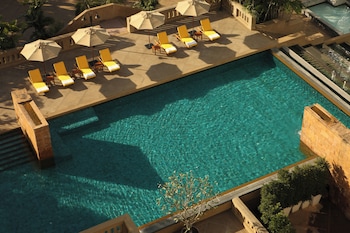 Een buitenzwembad en ligstoelen