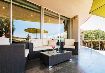 A hotel lobby with a revolving door, a reception desk, and a glass wall offering a view of the outdoors.