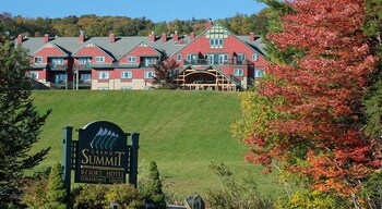 A red building with a stone fire pit and outdoor seating.