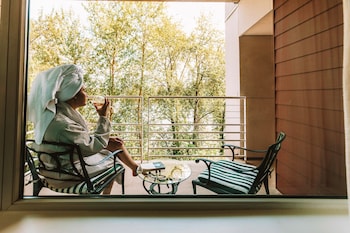 Welcome to our spacious lobby, featuring a comfortable seating area with a sofa and chairs, a reception desk, and a large window offering a view of the outdoors.