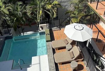 Alberca al aire libre, sombrillas en la alberca y camastros 